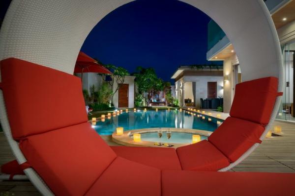 Pool Area With Red Leisurely Seating At Night